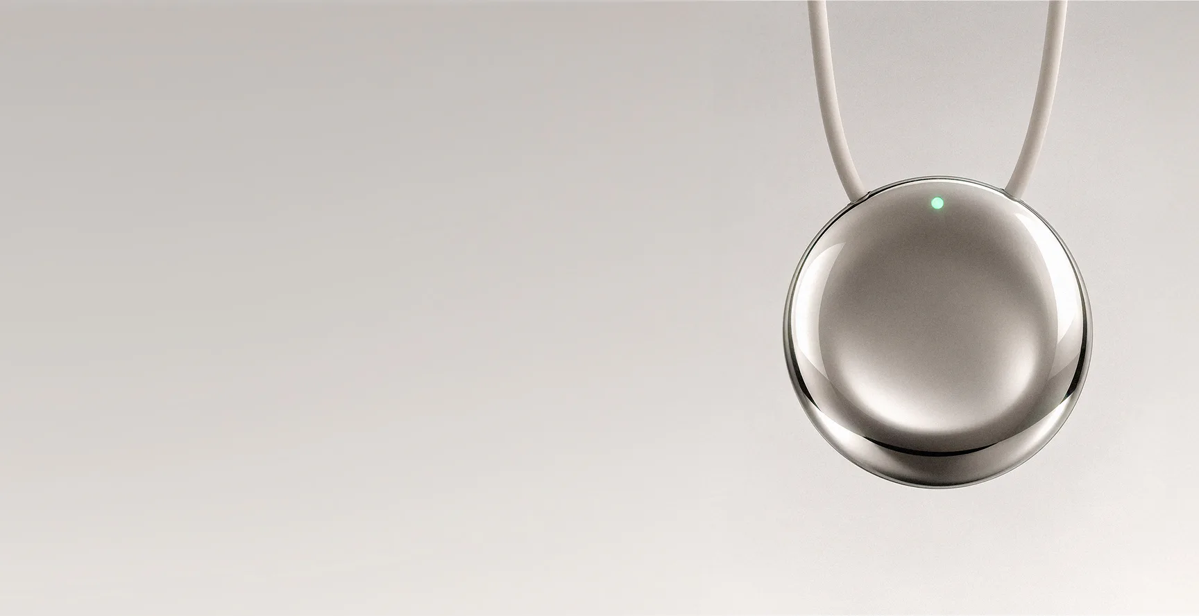 The Pebb pendant on a cord against a warm beige background